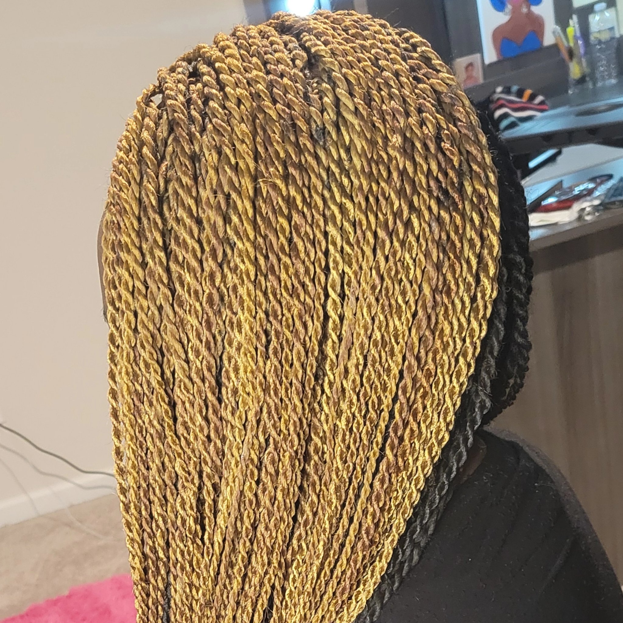 Blonde Senegalese twists in a gold and honey blend, full and long, back view