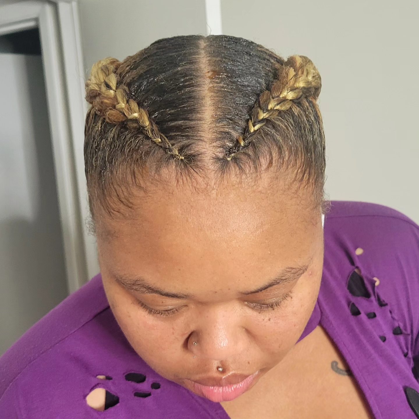 Blonde feed-in braids in two neat rows with a center part, front view