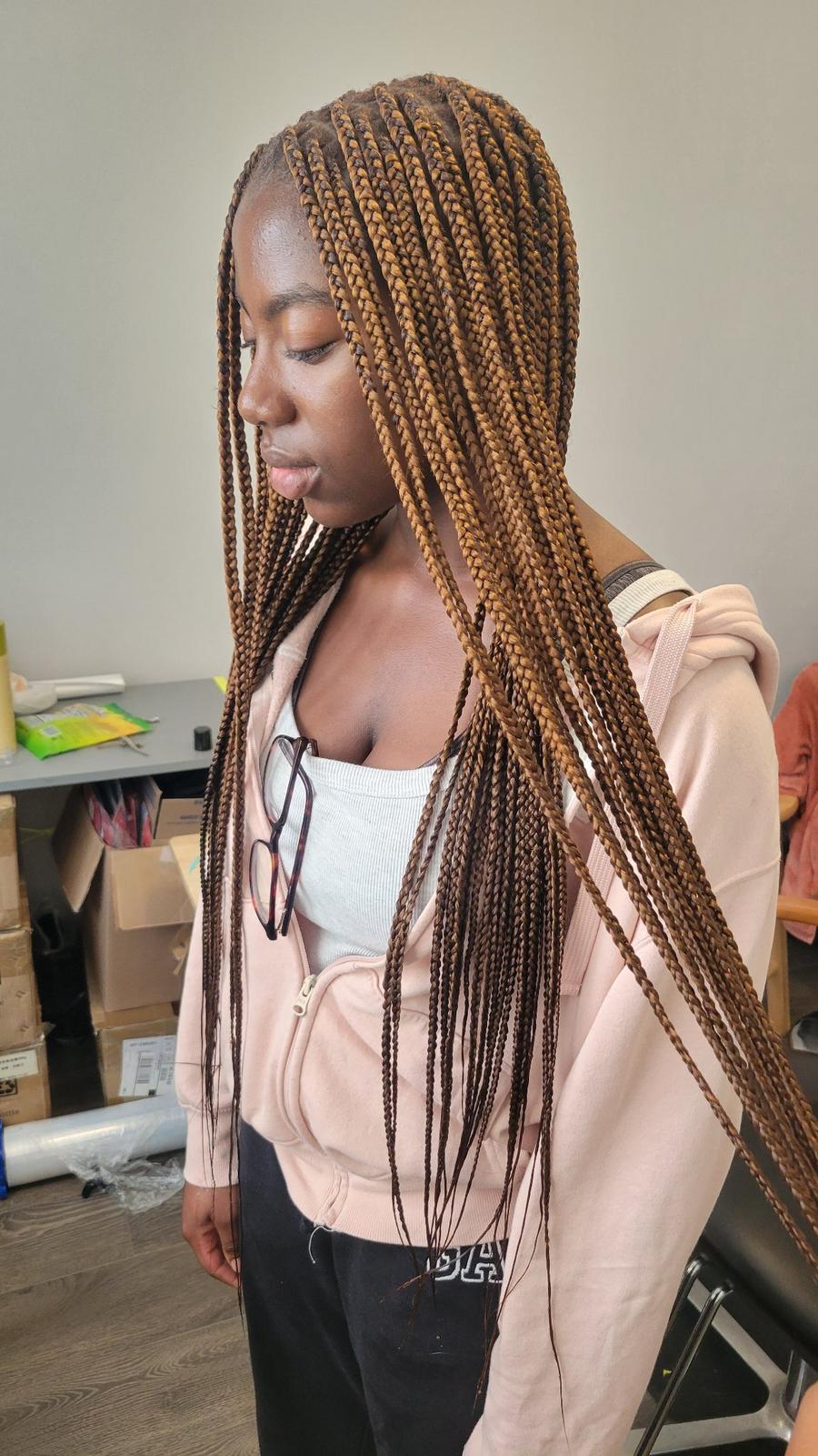 Knotless braids in honey brown, long and sleek, side view