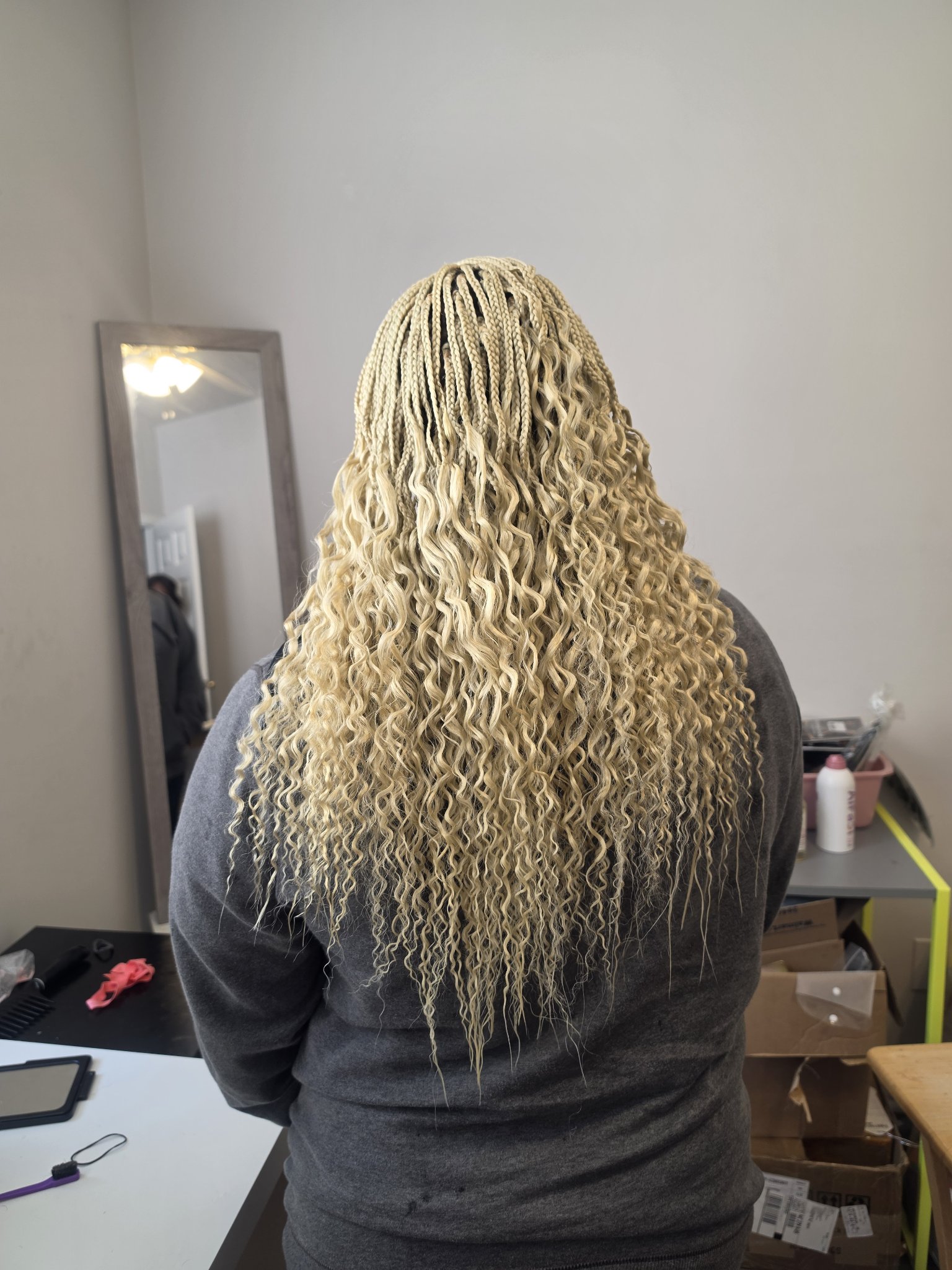 Micro braids in platinum blonde seen from behind with long wavy curly ends